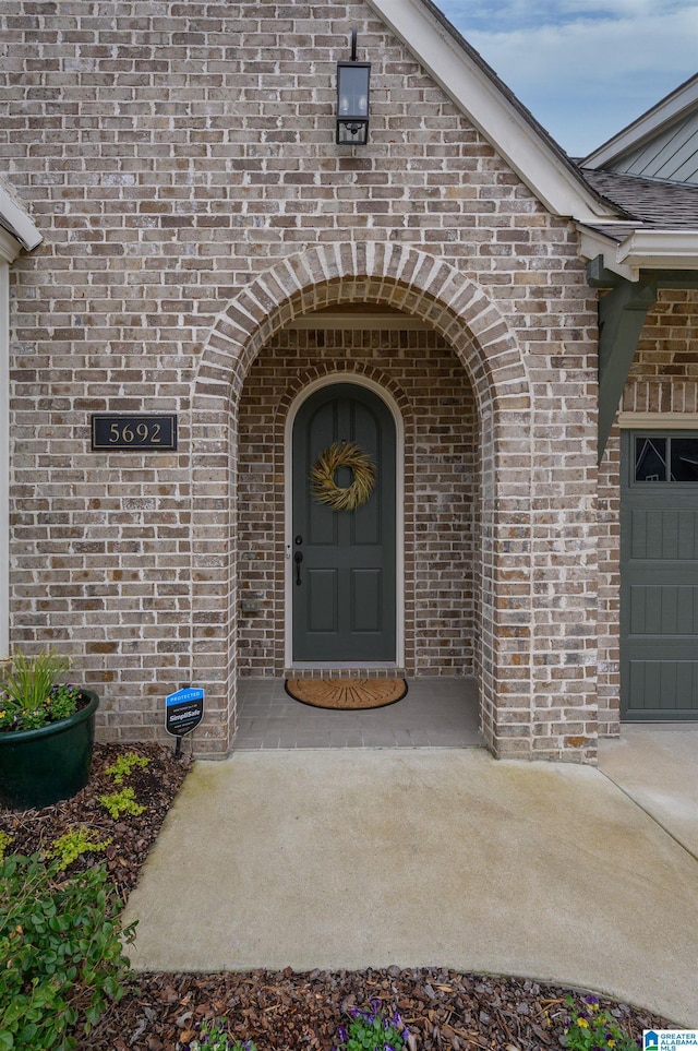 view of exterior entry with brick siding