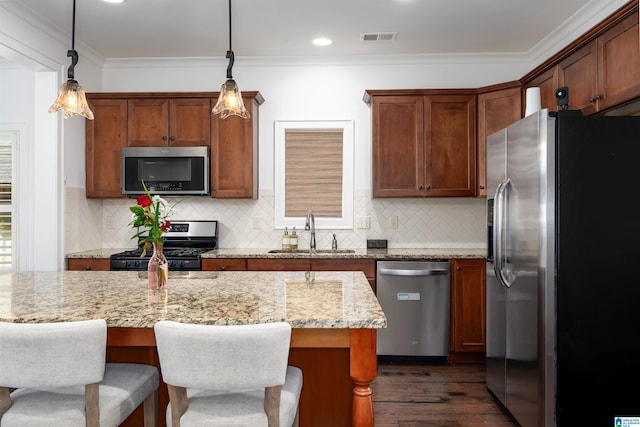 kitchen featuring hanging light fixtures, visible vents, stainless steel appliances, and a sink