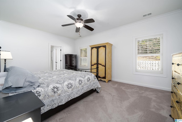 carpeted bedroom with visible vents, crown molding, baseboards, and ceiling fan