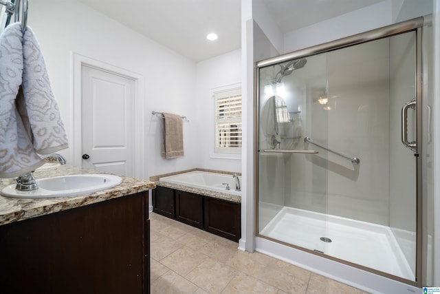 bathroom with a stall shower, recessed lighting, a garden tub, and vanity