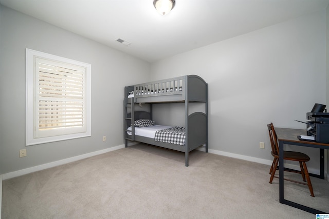 bedroom featuring baseboards, visible vents, and light colored carpet