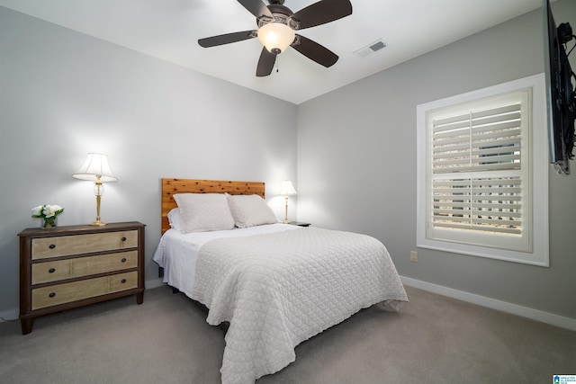 carpeted bedroom with a ceiling fan, visible vents, and baseboards