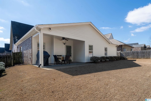 back of house featuring ceiling fan, brick siding, a patio area, and fence