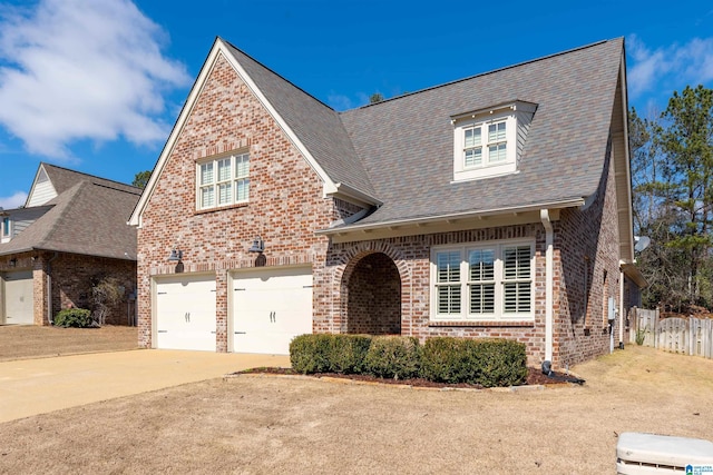 view of front of house featuring brick siding, a shingled roof, concrete driveway, fence, and a garage