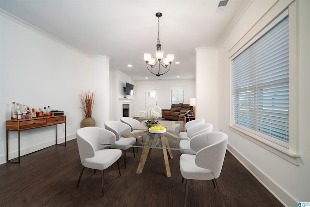 living area featuring a notable chandelier, dark wood-style flooring, a fireplace, visible vents, and baseboards