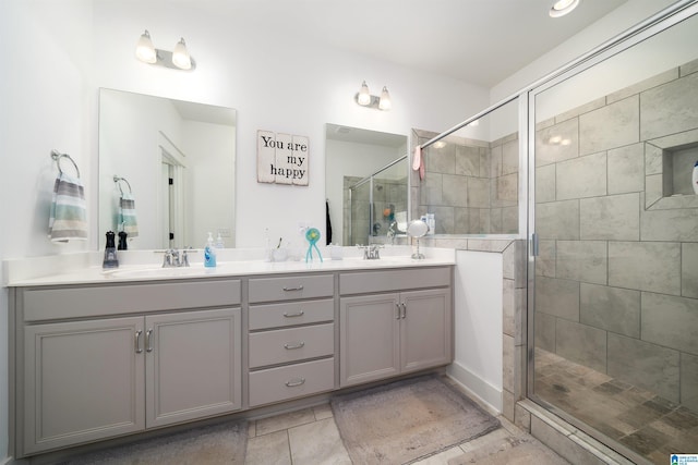 full bath with double vanity, a shower stall, and a sink