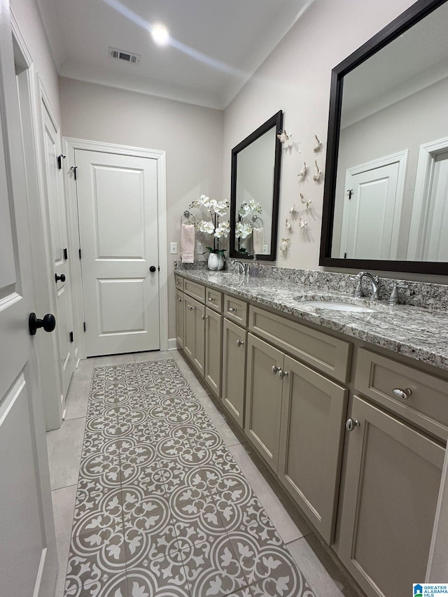 bathroom with tile patterned flooring, visible vents, a sink, and double vanity