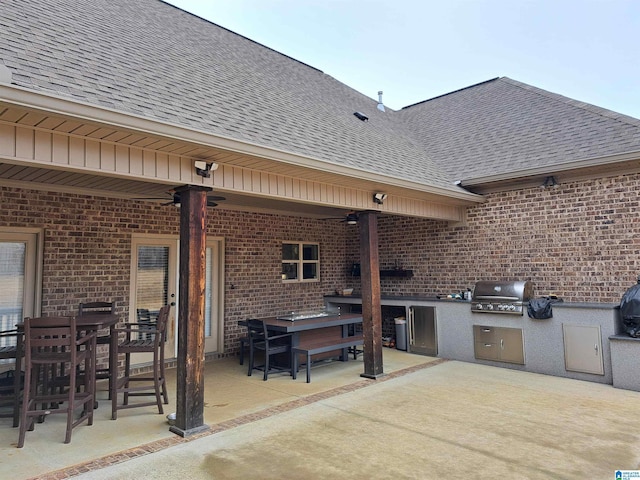 view of patio / terrace featuring a grill, an outdoor kitchen, and a ceiling fan