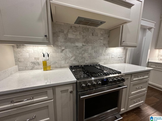 kitchen featuring light stone counters, dark wood-type flooring, exhaust hood, backsplash, and high end range