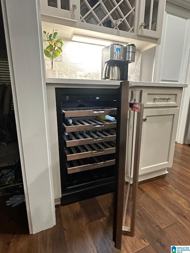 bar with beverage cooler and dark wood finished floors