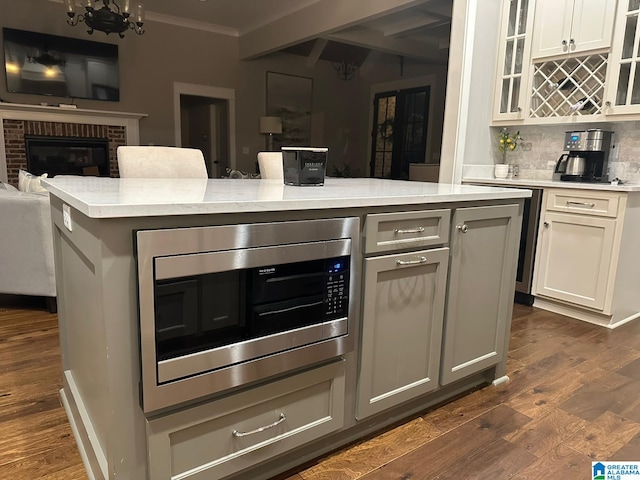 kitchen with dark wood-style floors, light countertops, open floor plan, and stainless steel microwave