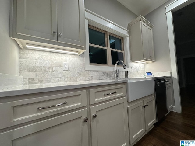 kitchen featuring dark wood-type flooring, a sink, light countertops, decorative backsplash, and dishwasher