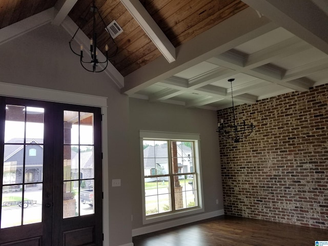 foyer with a notable chandelier, brick wall, visible vents, french doors, and beamed ceiling