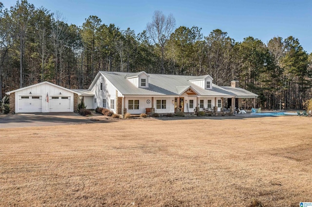 view of front facade featuring metal roof, a porch, and a front yard