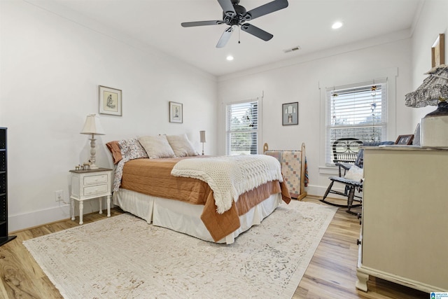 bedroom featuring ornamental molding, visible vents, and multiple windows
