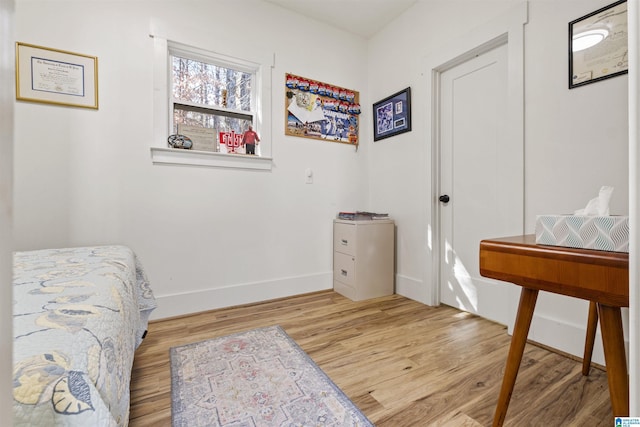 bedroom featuring baseboards and wood finished floors