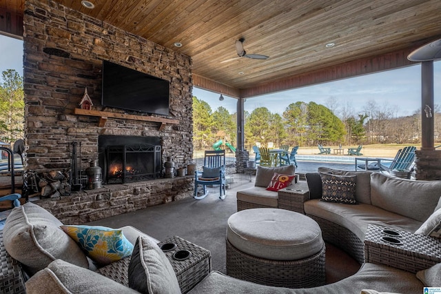 view of patio / terrace with an outdoor living space with a fireplace, a swimming pool, and a ceiling fan