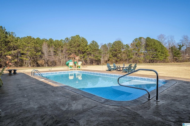 pool featuring playground community and a patio area
