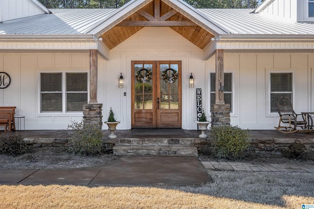 property entrance with board and batten siding, french doors, a porch, and metal roof