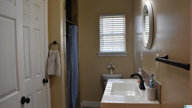 full bath featuring a stall shower, a sink, and toilet