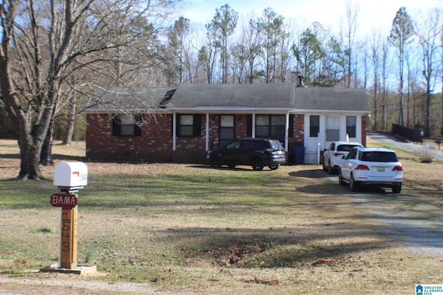 ranch-style home featuring driveway, brick siding, and a front yard