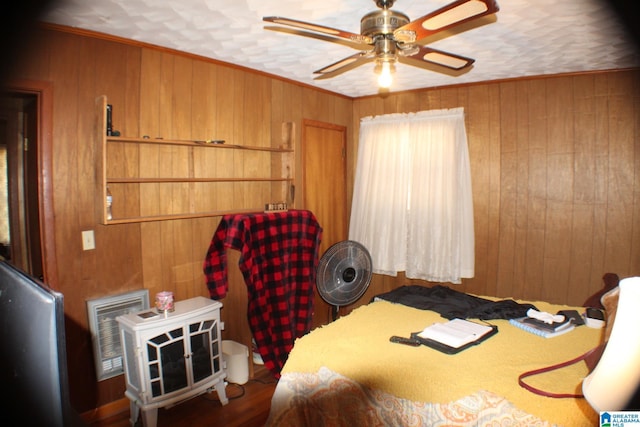 bedroom with ceiling fan, wood walls, and crown molding