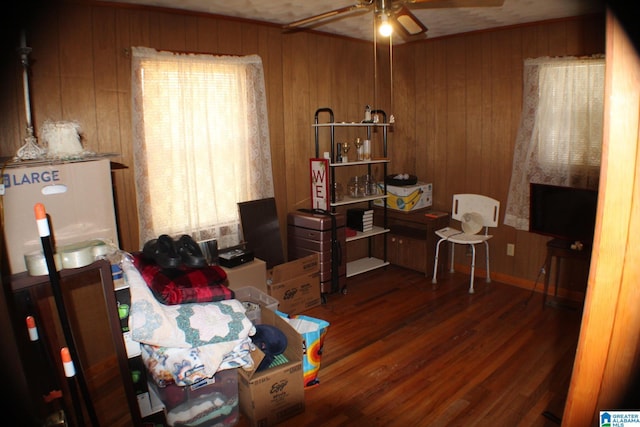 interior space with dark wood-style floors, ceiling fan, and wooden walls