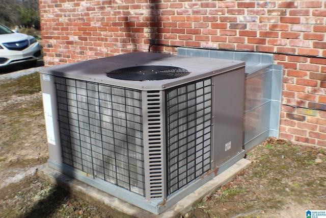 details featuring central AC unit and brick siding