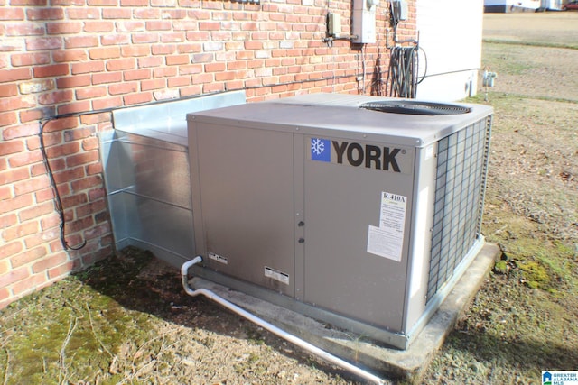 details featuring central AC unit and brick siding