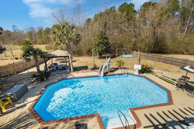 view of swimming pool with a fenced in pool, a water slide, a patio, and a gazebo