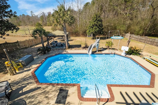 view of swimming pool with a fenced in pool, a fenced backyard, a water slide, a gazebo, and a patio area