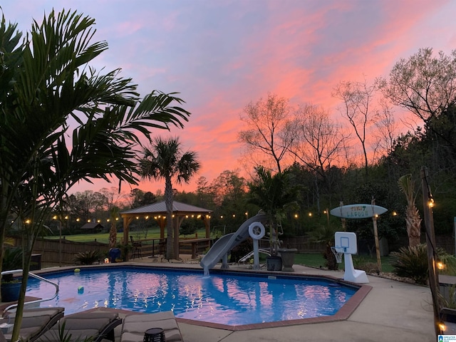 view of pool with a gazebo, a water slide, fence, and a fenced in pool