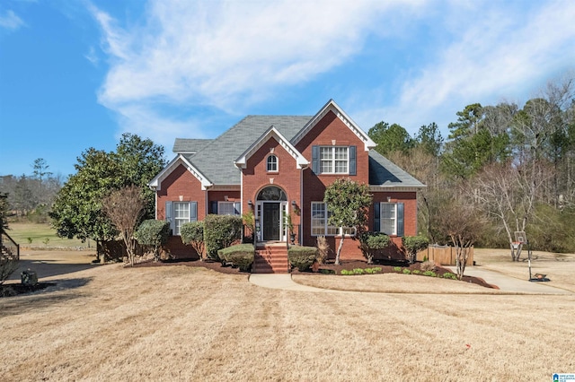 traditional home with a front lawn and brick siding