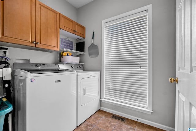 laundry area with baseboards, visible vents, cabinet space, and washer and dryer