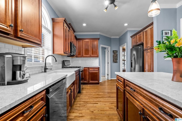 kitchen with refrigerator with ice dispenser, light wood-style floors, ornamental molding, stainless steel range with gas cooktop, and dishwasher