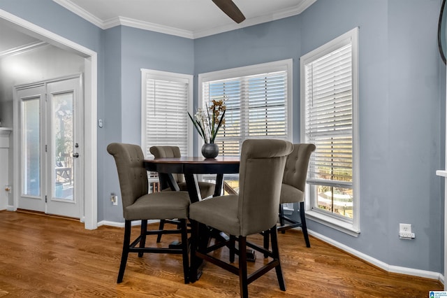 dining room featuring ornamental molding, wood finished floors, and baseboards