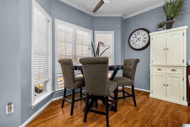 dining room featuring ornamental molding, wood finished floors, a ceiling fan, and baseboards