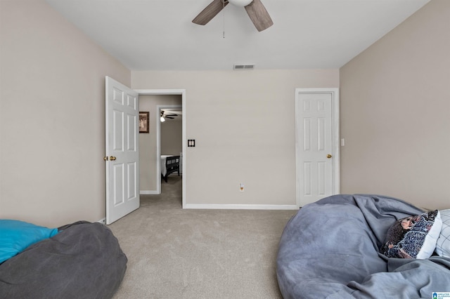 living area featuring baseboards, visible vents, ceiling fan, and light colored carpet