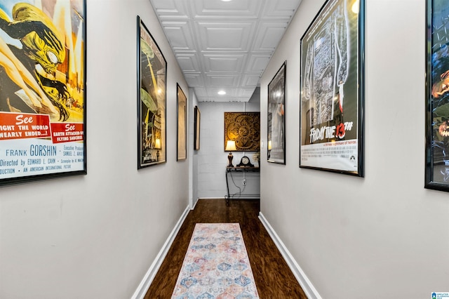 corridor featuring baseboards, wood finished floors, and recessed lighting