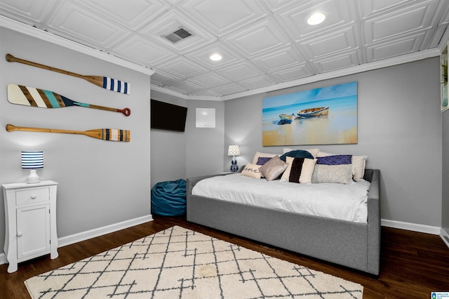 bedroom with an ornate ceiling, visible vents, baseboards, and wood finished floors