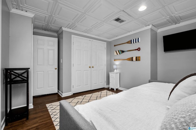 bedroom featuring baseboards, visible vents, an ornate ceiling, wood finished floors, and a closet