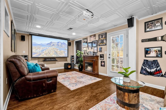 interior space featuring an ornate ceiling, a lit fireplace, baseboards, and wood finished floors