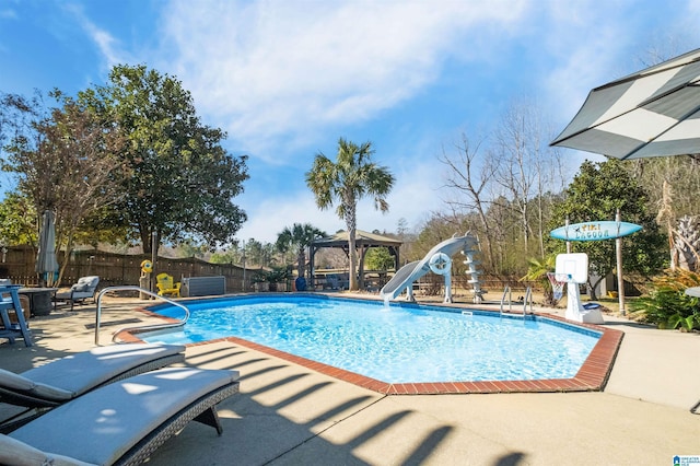 view of swimming pool featuring a fenced in pool, a patio, fence, a water slide, and a gazebo