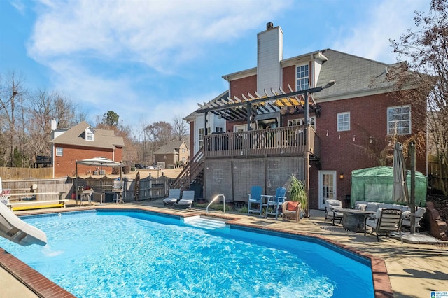 view of swimming pool featuring a patio, a water slide, fence, stairway, and a pergola