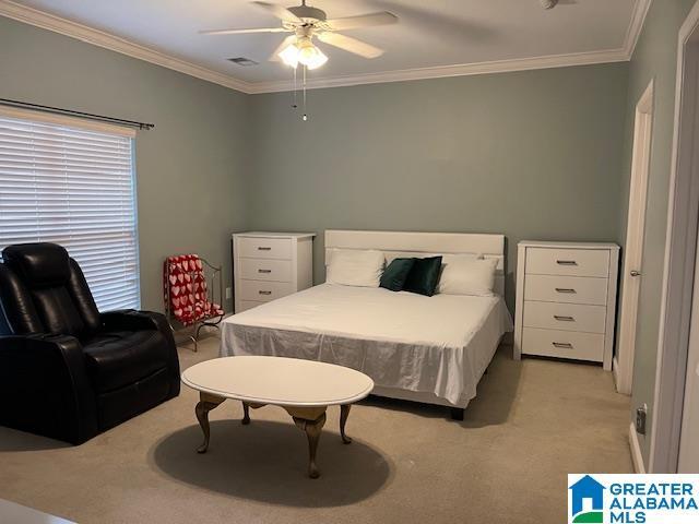 bedroom with light carpet, visible vents, ornamental molding, and ceiling fan