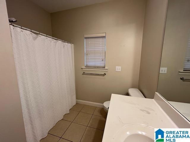 bathroom with toilet, tile patterned flooring, and baseboards