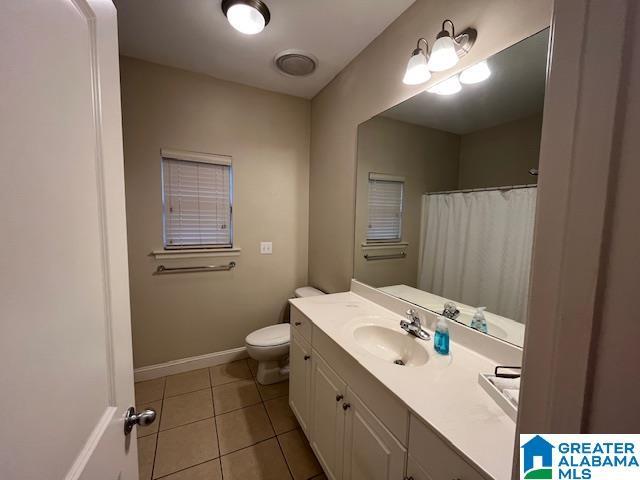 full bath with toilet, vanity, baseboards, and tile patterned floors