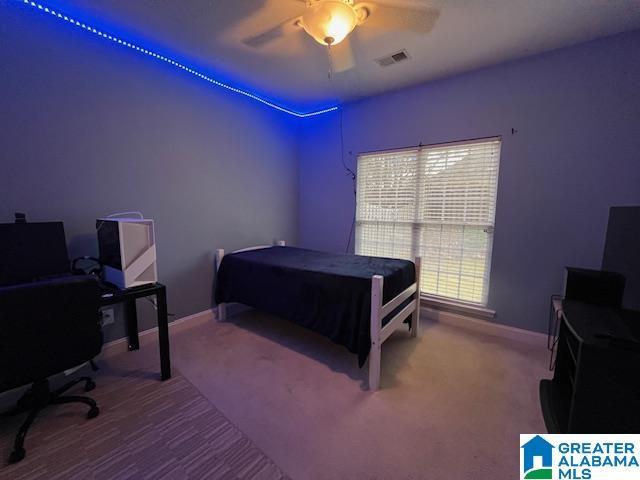 carpeted bedroom featuring baseboards, visible vents, and a ceiling fan