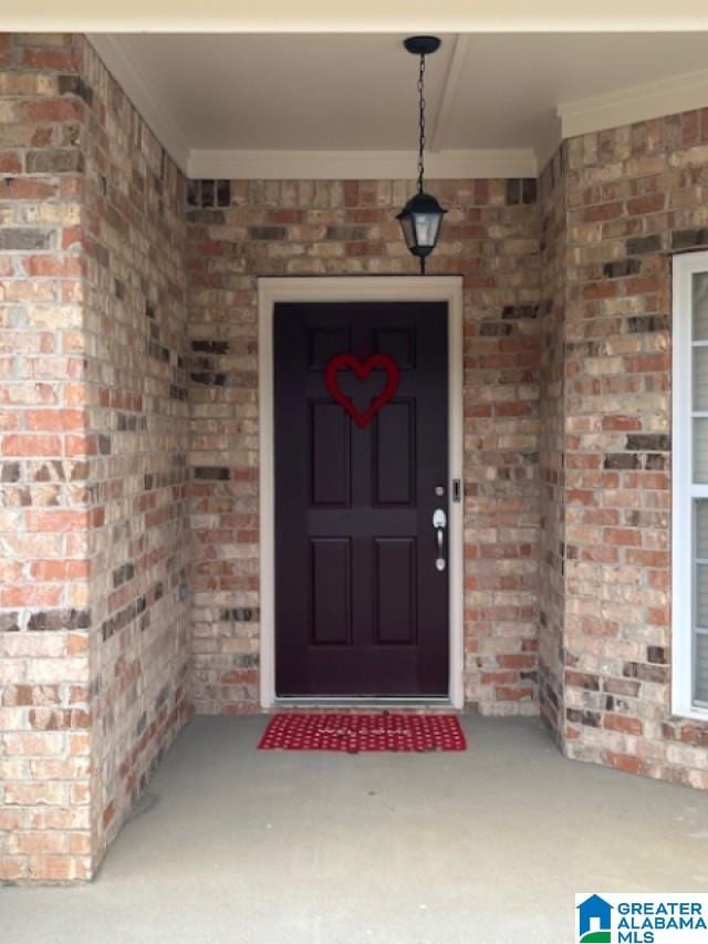 view of exterior entry featuring brick siding