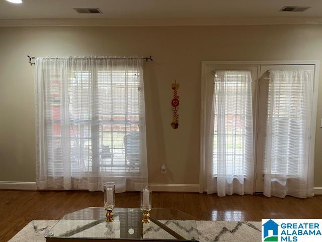 dining room featuring wood finished floors, visible vents, and crown molding